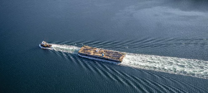 A tug boat pulling a barge, seen from above